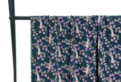 Fast viscose med hvide pumaer på grene med lilla blade og lilla og hvide blomster vist draperet over stang og fra afstand
