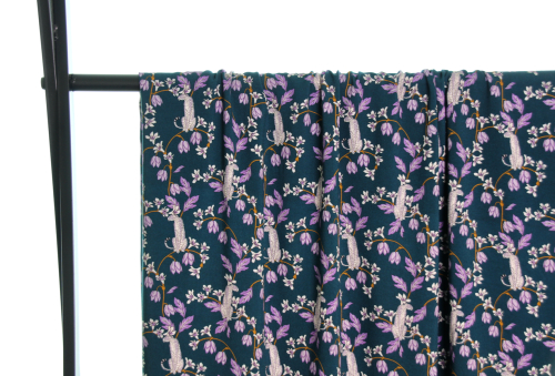 Fast viscose med hvide pumaer på grene med lilla blade og lilla og hvide blomster vist draperet over stang og fra afstand