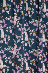 Fast viscose med hvide pumaer, der sidder på grene med lilla blade og lilla og hvide blomster vist tæt på