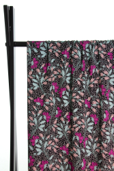 Fast viscose med små hvide prikker og blomster i lilla og blå toner på sort baggrund fra Atelier Jupe