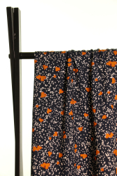 Fast viscose med hvide pletter og okkerfarvede hjerter på mørkeblå baggrund fra Atelier Jupe draperet over stang