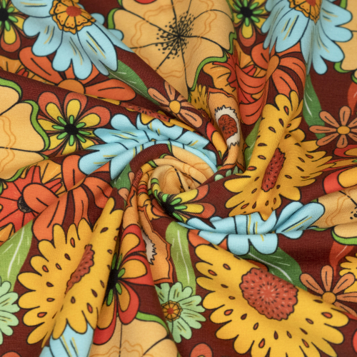 Bomuldsjersey med orange, gule, grønne, røde og turkise retroblomster i forskellige størrelser set tættere på