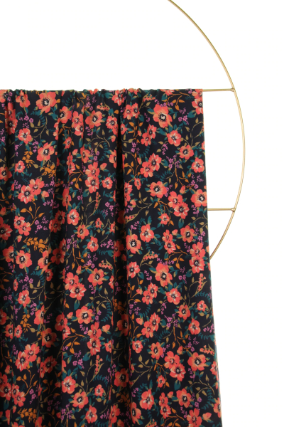 Fast viscose med små blomster - navy fra Atelier Jupe draperet over stang