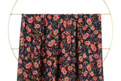 Fast viscose med små blomster - navy fra Atelier Jupe draperet over stang og vist tættere på