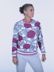 Kvinde i farverig trøje med blomsterprint poserer med et mildt smil.