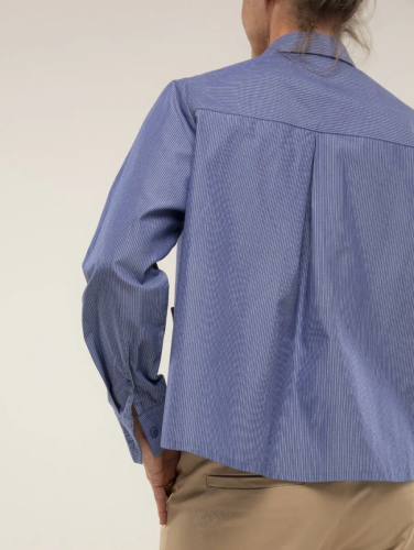 Person iført en blåstribet skjorte set bagfra.
