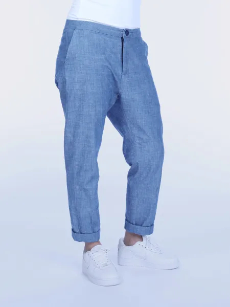 Person iført lyseblå bukser og hvide sneakers.