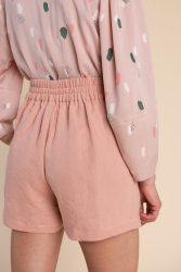 Billede af bukser en glat front foran, høj talje og elastik bagpå set bagfra i nærbillede